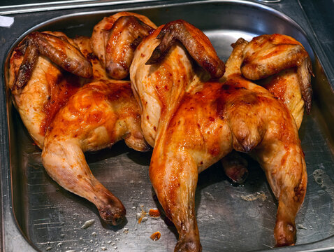 Cooked chickens presented in a supermarket deli, highlighting ready to eat grilled poultry offered for sale in a grocery food section