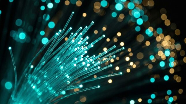 An extreme close-up view of glowing teal fiber optic cables radiating brilliantly against a dark background, creating a vibrant network of light patterns and technological lines