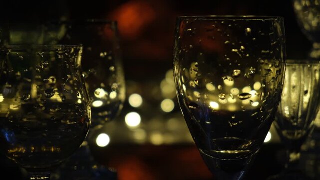 Empty champagne flutes and festive cocktail glasses are elegantly arranged on a beautifully set table, poised for the perfect holiday toast. Warm golden glows