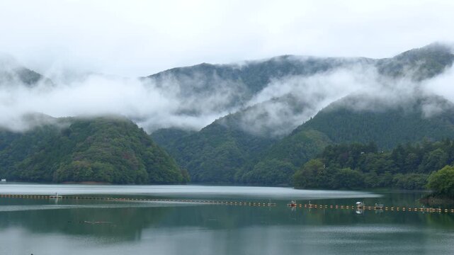 雲に覆われる奥多摩湖と山々の風景