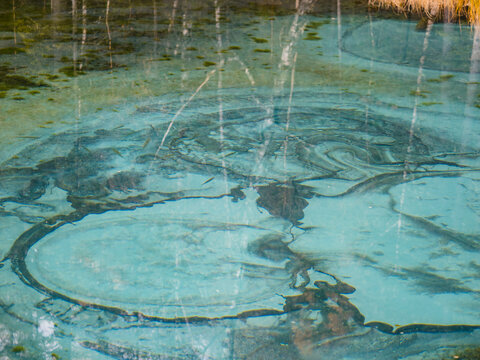 Close up view of amazing turquoise water and bottom of Geyser lake. Beautiful Blue Geyser lake with thermal springs that throw clay and silt. Geyser Lake is natural attraction, Aktash, Altai mountains