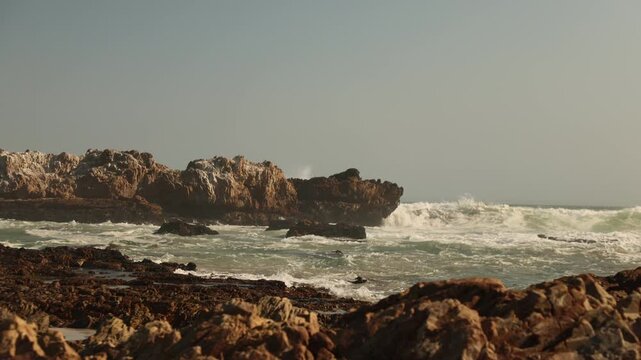 big waves crashing into massive rock, Kammabaai Beach, Hermanus, South Africa