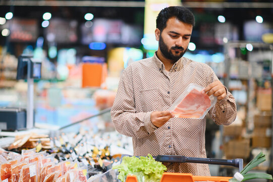 Indian man shopping for meat at supermarket
