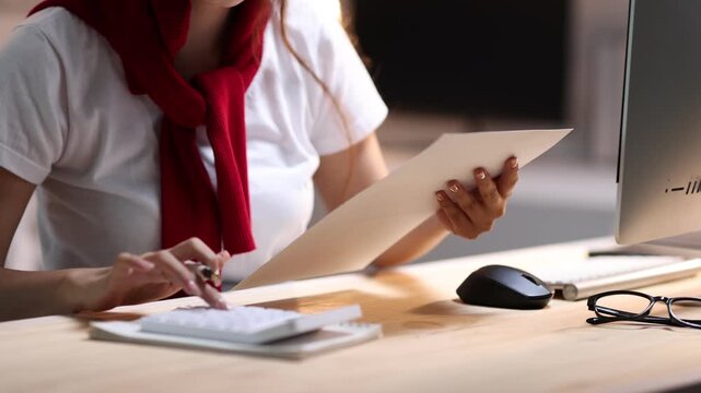 Accountant calculating budget with charts and calculator.