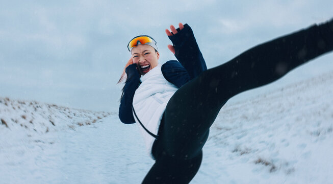 The woman brings playful energy to training outdoors in winter snow