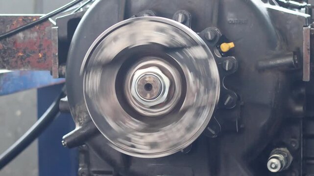 A metallic output flange spins rapidly during transmission testing indoors.