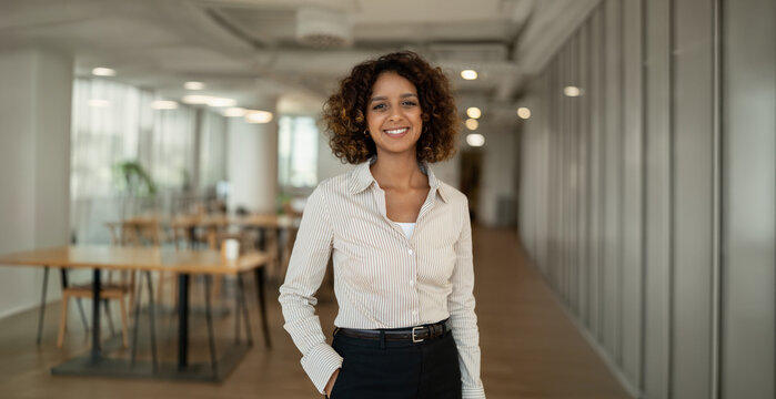 Web banner of latin business woman standing for portrait in coworking office workplace, looking at camera. In 30s, female leader works as specialist, consultant, director, founder. Copy space