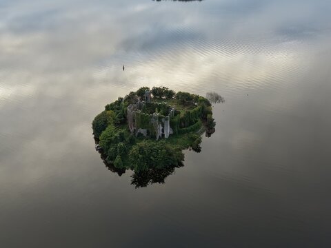 Aerial photograph of the historic ruins of McDermotts Castle on Castle Island in Lough Key, County Roscommon, Ireland. The isolated wooded island is surrounded by calm lake water with subtle