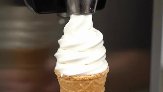 Soft serve ice cream machine dispensing vanilla swirl cone in commercial restaurant