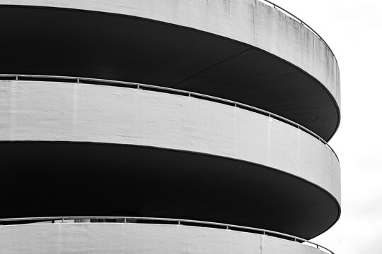 Close-up of a spiral concrete ramp of a multi-storey parking garage in Dortmund, Germany, photographed in black and white with sweeping curves, strong contrasts and minimalist architectural geometry.