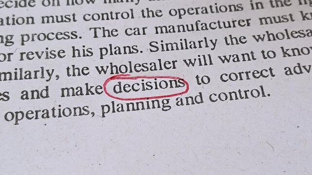 Hand with red ink pen mark circle around to emphasize or highlight decisions word on document, book or paper. Taking hard and bad mental decisions in personal and business life symbolic concept.