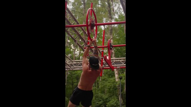The athlete is navigating an obstacle course consisting of monkey bars