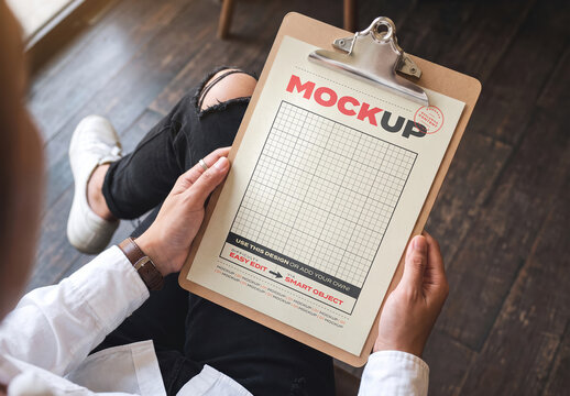 Person Holding Menu Page with Clipboard on Lap Page Mockup
