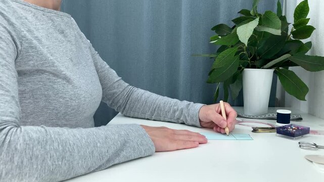 A novice female tailor is drawing lines on a skirt mock‑up; learning to sew at home, a hobby, making clothes with your own hands