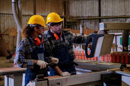Workers in a manufacturing facility using tools and equipment for production tasks during the workday