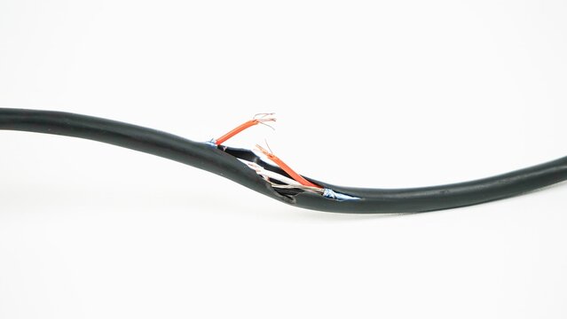 Close-up shot of a damaged black electric power cable with broken outer insulation exposing stripped inner copper wires, isolated on a clean white background
Category 1