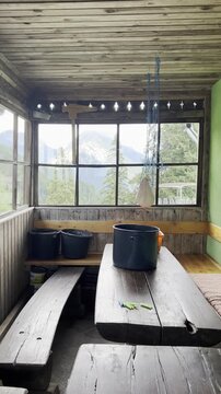 Slovenian Alps rural landscape. Rustic veranda with mountain view and homemade cheese draining into a bowl.