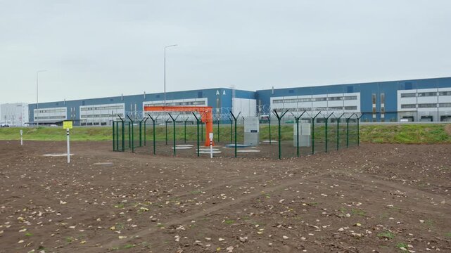 Ground with closed sewage hatches and orange hoist at wastewater treatment plant. Access to underground reservoirs at modern station
