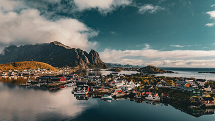 High angle panoramic view of Reine village with red cabins and bridges surrounded by fjord and mountains in Lofoten Norway © Quality by Simon
