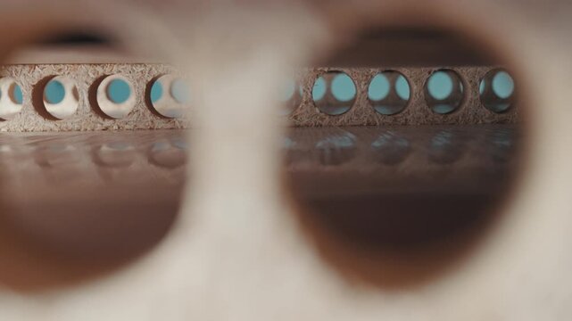 Creative macro probe view looking through hollow core holes of tubular particle board pallet base