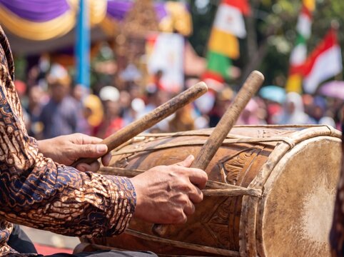 Drummer playing bedug festival drum with sticks