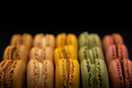 macaroons of different colors on a black background