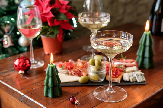 Festive Holiday Table With Champagne Glasses, Charcuterie Board, Poinsettia and Christmas Candles