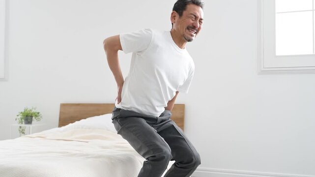 腰を押さえて痛がる50代の日本人男性