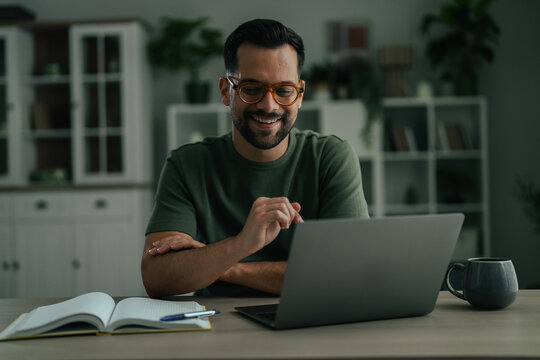 Man smiling while telecommuting from home office