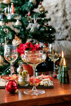 Festive Holiday Table With Champagne Glasses, Charcuterie Board, Poinsettia and Christmas Candles
