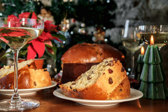 Festive Christmas Table With Sliced Panettone, Champagne Glasses, Poinsettia and Holiday Candles