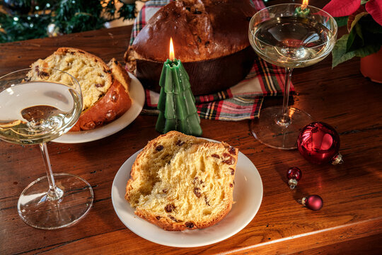 Festive Christmas Table With Sliced Panettone, Champagne Glasses, Poinsettia and Holiday Candles