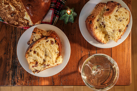 Festive Christmas Table With Sliced Panettone, Champagne Glasses, Poinsettia and Holiday Candles