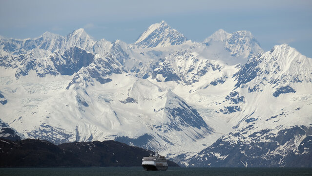 Breathtaking mountain glacier range view with luxury cruiseship cruise ship liner Zaandam Volendam sailing in front of Alaska mountains with spectacular landscape scenery Endicott Arm Fjord