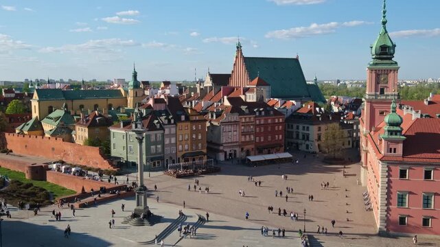 High angle view of Plac Zamkowy in Warsaw with Sigismunds Column, St Johns Archcathedral, Old Town rooftops, and blue sky