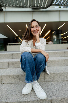 Young woman smiling sitting on urban steps