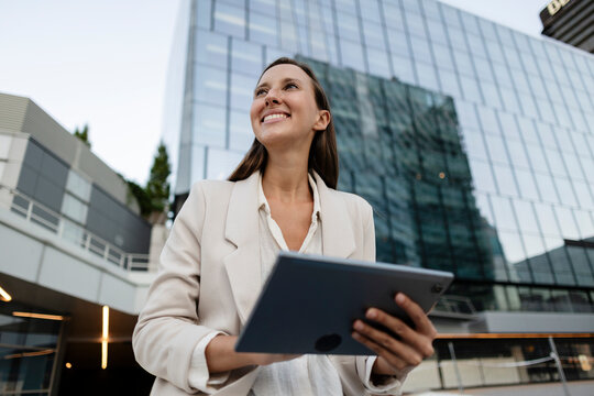 Confident businesswoman using digital tablet in urban setting