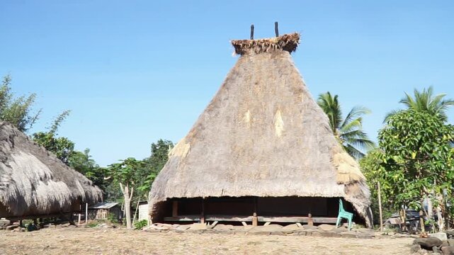 Traditional vernacular house with thatched straw roof under clear blue sky