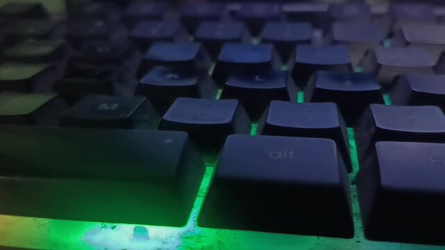 Close-Up of RGB Mechanical Gaming Keyboard with Rainbow Backlighting in the Dark