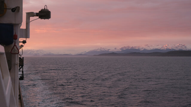 Breathtaking Alaska mountain glacier range view seen from outdoor deck of cruise ship liner sailing the Inside Passage transit with spectacular landscape scenery during sunset