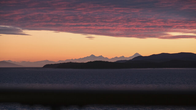 Breathtaking Alaska mountain glacier range view seen from outdoor deck of cruise ship liner sailing the Inside Passage transit with spectacular landscape scenery during sunset