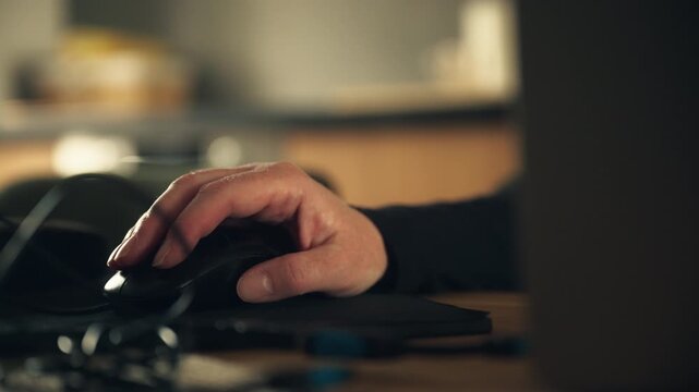 Person operating desktop computer with mouse in low light workspace, productivity and digital lifestyle scene, 4K