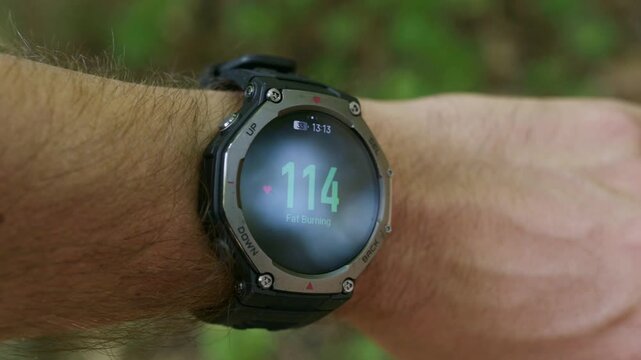 Smartwatch displaying fat burning zone heart rate 117 bpm on a male wrist