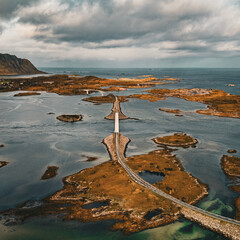 Aerial view of winding coastal road and bridges connecting rocky islands in scenic fjord landscape in Lofoten Norway © Quality by Simon