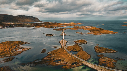 Aerial view of winding coastal road and bridges connecting rocky islands in scenic fjord landscape in Lofoten Norway © Quality by Simon