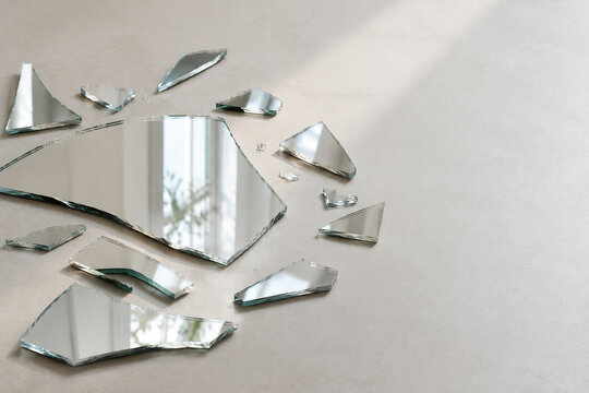 Scattered mirror fragments on light floor, reflection and self image concept