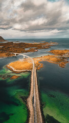 Vertical drone aerial view of coastal road and bridges connecting rocky islands in fjord landscape in Lofoten Norway © Quality by Simon