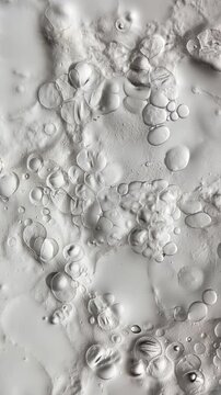 Banana stem sap containing microscopic lipid microdroplets, resin particles, and organic emulsion forming spherical structures that dynamically pop and collapse, leaving behind micro-craters 