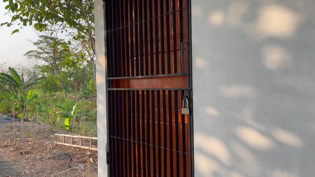 Locked Iron Gate of Private Property with Padlock and Outdoor Landscape