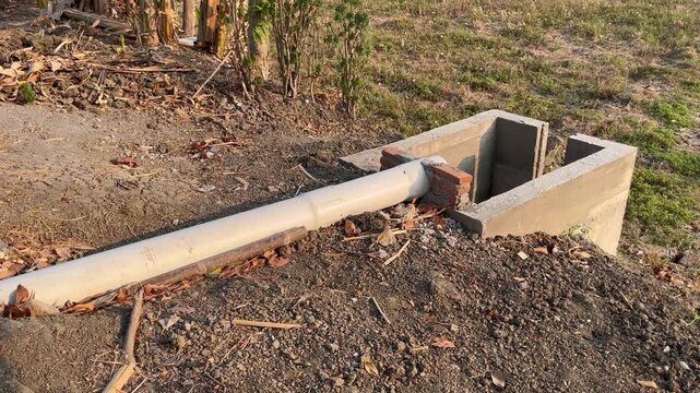 PVC Drainage Pipe and Concrete Catch Basin in Rural Field